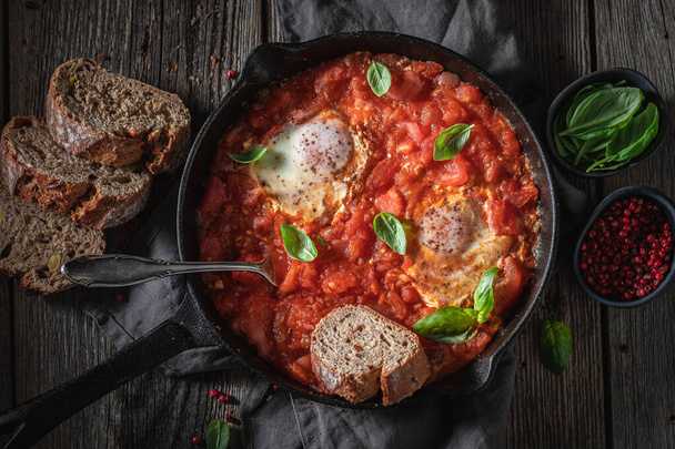 Homemade shakshuka with tomatoes, eggs and herbs - Foto, Imagen