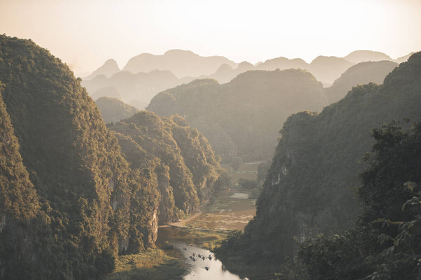 Tam Coc, Ninh Binh, Vietnam 'daki Mua Mağaraları ve Ejderha Heykeli' nden Vietnam nehirlerinin ve manzaranın üzerinde güzel bir gün batımı. - Fotoğraf, Görsel