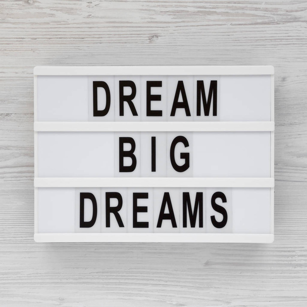 "Große Träume träumen" steht auf einem Leuchtkasten auf einer weißen Holzoberfläche - Foto, Bild