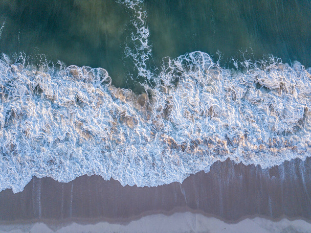 Drone obraz fal uderzających na plaży. - Zdjęcie, obraz