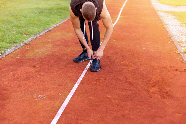 Man tying shoes on the race track - Foto, afbeelding