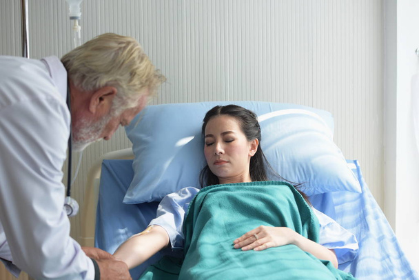 O médico está cuidando do paciente e checando o corpo e conversando com o paciente no hospital
 - Foto, Imagem