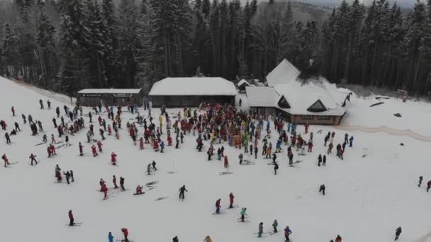 Photographie aérienne dans les montagnes d'une station d'hiver. Pistes de ski sur les pistes de montagne. Paysage hivernal de sommets enneigés avec forêt dense de pins
. - Séquence, vidéo