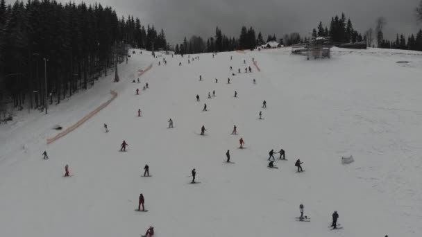 Fotografía aérea en las montañas de un complejo invernal. Pistas de esquí en las pistas de montaña. Paisaje invernal de picos nevados con denso bosque de pinos
. - Metraje, vídeo