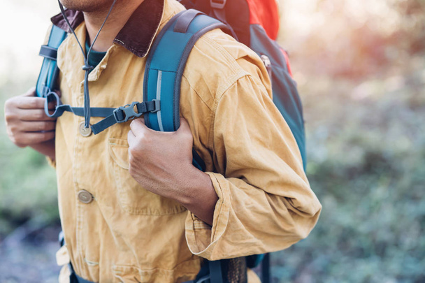 close up backpack man hiking traveling on forest in travel Lifestyle wanderlust adventure with enjoying on nature. Tourist traveler on background valley landscape view. - Photo, Image