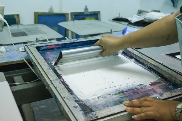 Hand pressing silk-screen printing, close up view. - Photo, Image