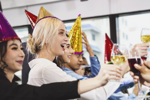 Biznesmeni odnoszący sukcesy w piciu szampana, rozmawianiu i uśmiechu podczas świętowania w biurze - Zdjęcie, obraz