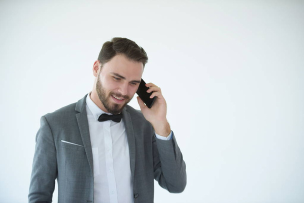 елегантний чоловік розмовляє смартфоном на білому тлі
 - Фото, зображення
