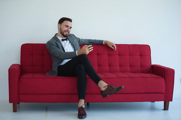 elegancja człowiek za pomocą smartfona podczas siedzenia na kanapie - Zdjęcie, obraz