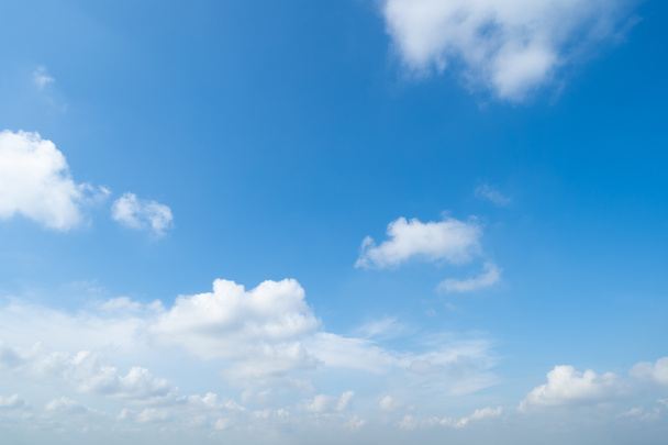 klarer blauer Himmel mit weißen, flauschigen Wolken zur Mittagszeit - Foto, Bild
