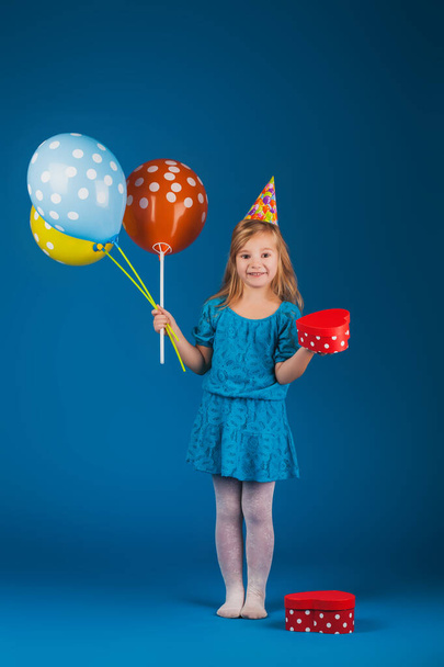 girl with gifts and balloons on the blue background. - Foto, Imagem