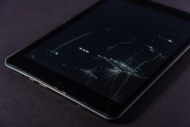 Image with broken display of a smartphone or tablet computer on black background. - Photo, Image