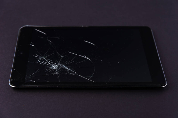 Immagine con display rotto di uno smartphone o tablet su sfondo nero
. - Foto, immagini