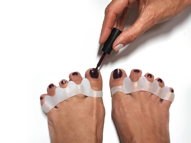 The master makes pedicures on toenails. Silicone finger device. - Photo, Image