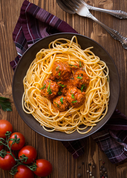 Delicious spaghetti with meatballs in tomato sauce on dark background, italian cuisine - Photo, Image