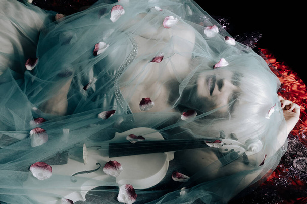 mladá blondýnka s bílou fialovou v noci ležící na posteli - Fotografie, Obrázek