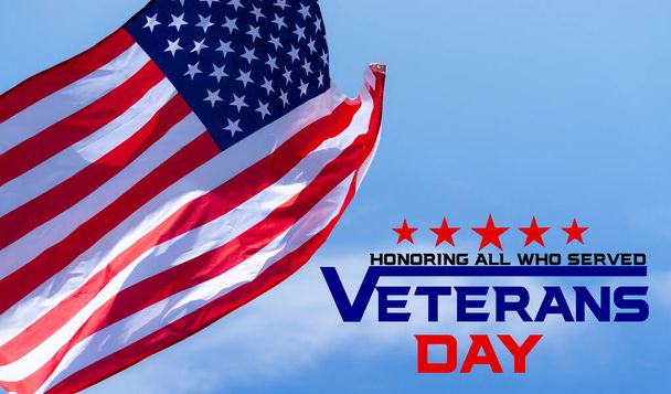 С Днем ветеранов с американскими флагами на фоне голубого неба
. - Фото, изображение