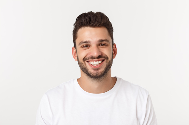 Πορτραίτο ενός όμορφου νεαρού άνδρα χαμογελώντας σε κίτρινο φόντο - Φωτογραφία, εικόνα