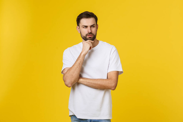 Pensive curious man looking up in thinking pose trying to make choice or decision isolated on yellow background. - Foto, Imagem