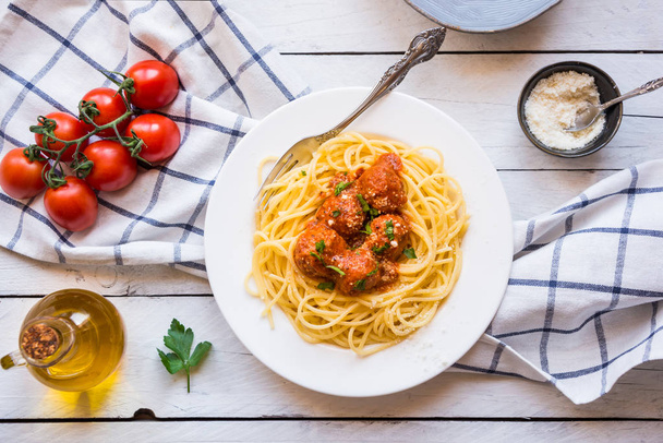 Herkullinen spagetti lihapullilla tomaattikastikkeessa valkoisella pohjalla, italialainen keittiö
 - Valokuva, kuva
