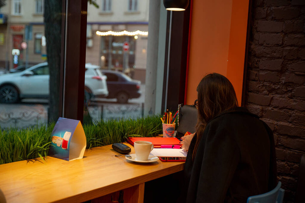 donna seduta in caffè bere riscaldare tè disegno di lavoro allo stesso tempo
 - Foto, immagini