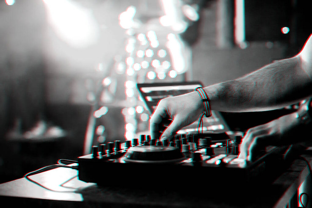 χέρια DJ ανάμειξη και αναπαραγωγή μουσικής σε ένα επαγγελματικό μίξερ ελεγκτή - Φωτογραφία, εικόνα
