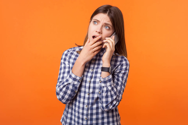 Portret zmartwionej młodej kobiety z brązowymi włosami rozmawiającej przez telefon - Zdjęcie, obraz