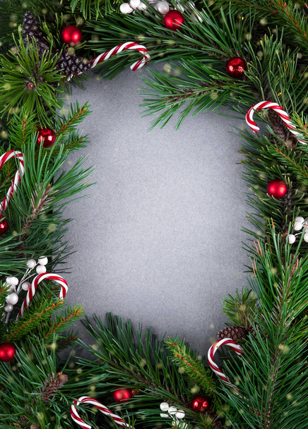 テキスト用のコピースペースを持つクリスマスや新年の背景。休日の概念。エコ再生紙の空白の灰色のカードとモミの枝や装飾で作られた創造的なレイアウト。トップ表示 - 写真・画像