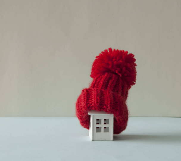 Cerca de casa modelo en miniatura conceptual con bufanda de lana roja ha
 - Foto, Imagen