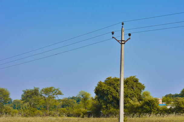 Concrete electric poles in a field under the beautiful blue sky - Photo, Image