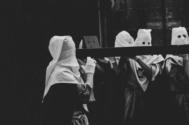 Membros da irmandade segurando a cruz
 - Foto, Imagem