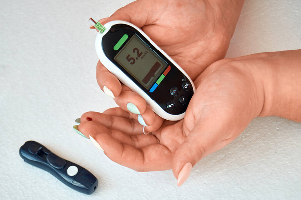 Um diabético verifica o nível de açúcar no sangue. A mulher é auto-testada com um Lancet e um glicosímetro em casa
. - Foto, Imagem