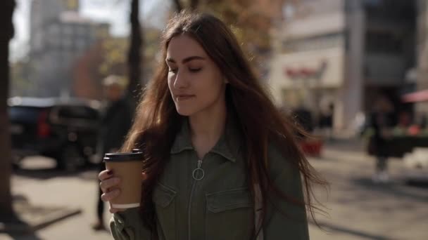 Όμορφη γυναίκα πίνει καφέ περπατώντας στην πόλη - Πλάνα, βίντεο