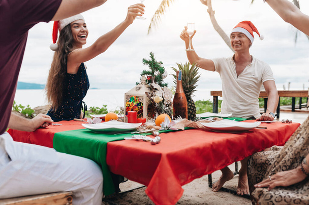 Friends celebrating Christmas or New Year eve at the beach. - Foto, Imagem