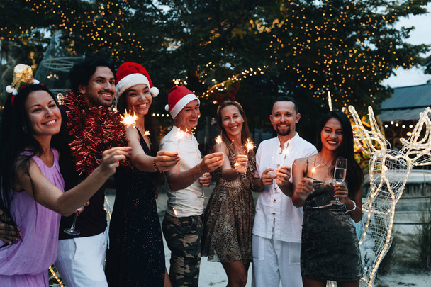 Grupa przyjaciół świętuje Boże Narodzenie z musujących i szampana - Zdjęcie, obraz