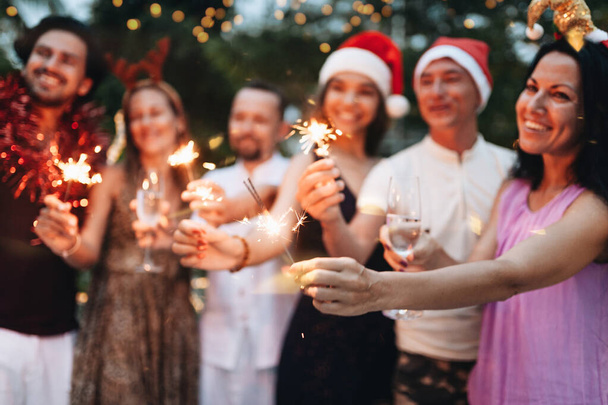 Grupa przyjaciół świętuje Boże Narodzenie z musujących i szampana - Zdjęcie, obraz