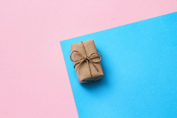 Gender determination day concept. Gift box wrapped in craft paper and tie hemp thread. Pink and blue backgrounds. Girl or boy. Birthday party. Header format. Long photo. - Фото, изображение