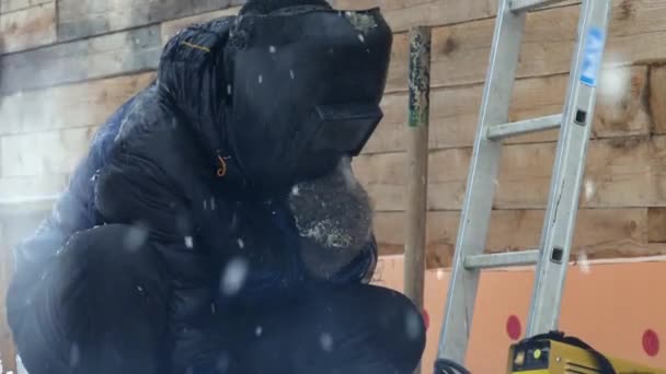 Homme soude des pièces métalliques à l'extérieur en hiver
. - Séquence, vidéo
