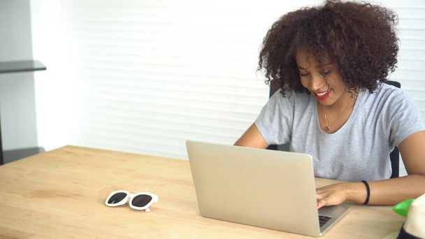Mujer africana que trabaja con el ordenador portátil de casa empresario serio
 - Foto, imagen