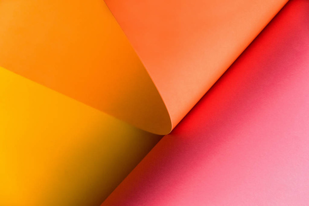 Papel rosa, laranja e amarelo abstrato dobrando-se em forma abstrata. Cor abstrato papel fundo
. - Foto, Imagem