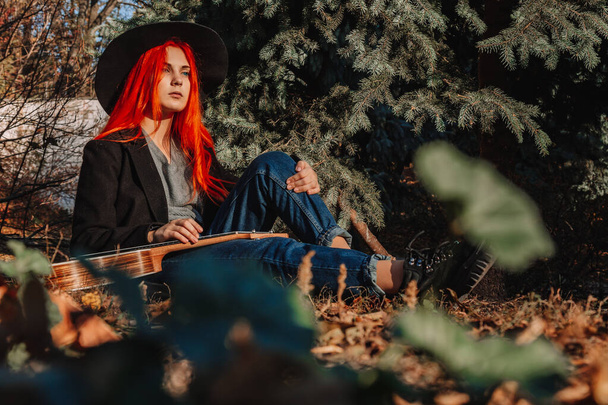 Sexy redhead girl with long hair plays the ukulele. Perfect woman portrait. Gorgeous strong and thick hair. Deep blue eyes. Natural beauty, clean skin, face and hair care. - Foto, afbeelding
