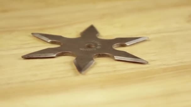 silver shuriken rotates 360 degrees on a wooden stand - Footage, Video