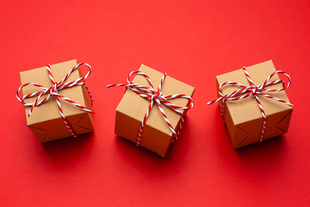 Christmas gifts on a colored red background. New Year, holiday, give, pack. - Фото, зображення