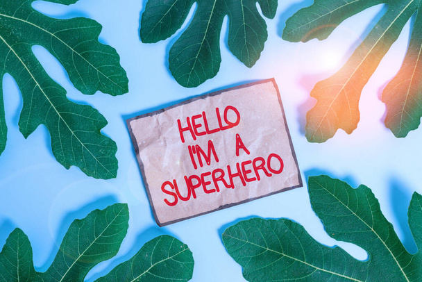 Writing note showing Hello I M A Superhero. Business photo showcasing Believing in yourself Selfconfidence Introduction Leaves surrounding notepaper above empty soft pastel table. - Photo, Image