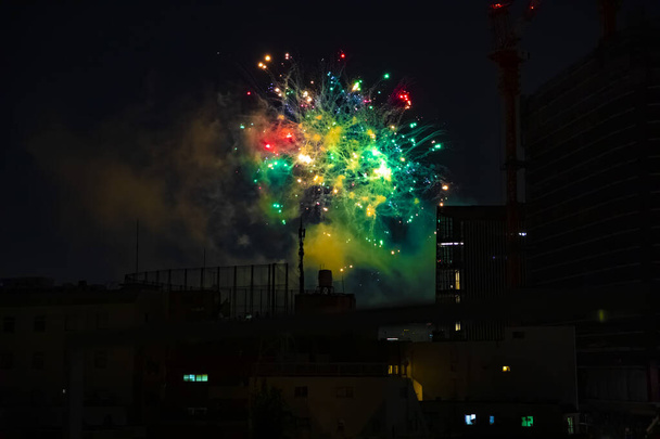 Фейерверки возле здания в городе Токио в летнюю ночь
 - Фото, изображение