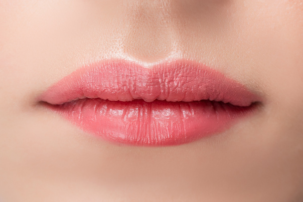 Hermosos labios femeninos naturales de cerca con palo de maquillaje permanente rosa
 - Foto, imagen