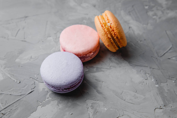Gâteau coloré rose, orange, violet Macaron ou macaron français ou italien sur fond gris béton
 - Photo, image