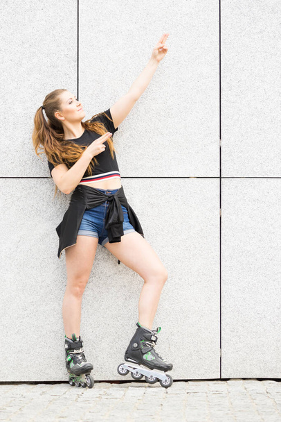 Young woman riding roller skates - 写真・画像
