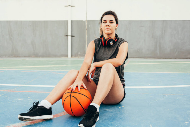 Young female basketball player training outdoors on a local court - Foto, afbeelding
