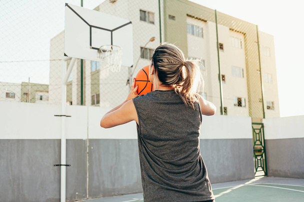 Young female basketball player training outdoors on a local court - Foto, Imagem